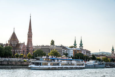 View of building by river against sky in city