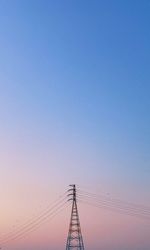 Low angle view of electricity pylon against clear sky