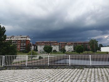 Buildings in city against cloudy sky