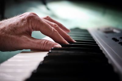 Cropped hand of woman playing piano