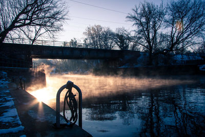 Bridge over river against sky during sunset