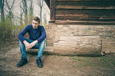 Portrait of young man standing on wall