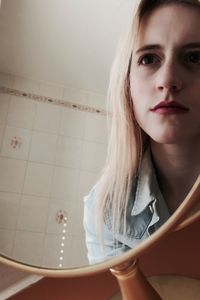 Close-up portrait of a young woman in bathroom