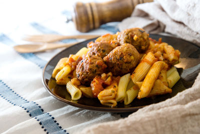 Close-up of meatballs in pasta on plate at table