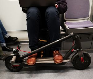 Low section of man with segway sitting in train