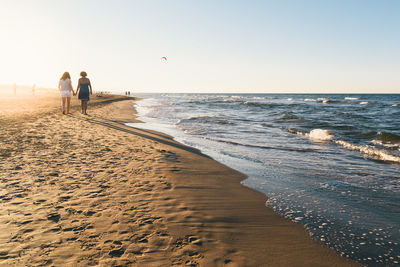 People at beach against sky