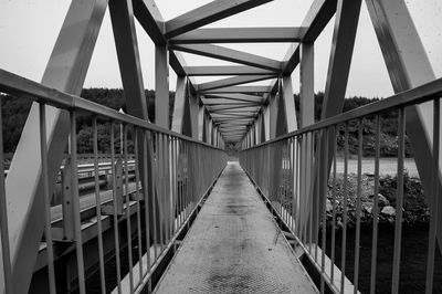 Footbridge over footpath against sky