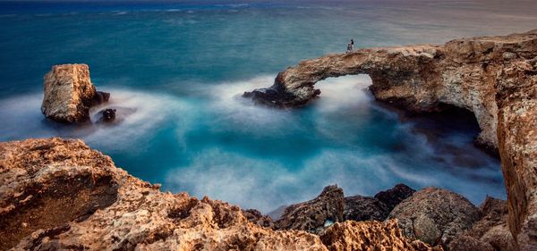 High angle view of rock formations by sea against sky