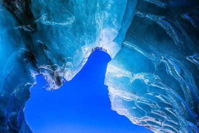 Low angle view of icicles against blue sky