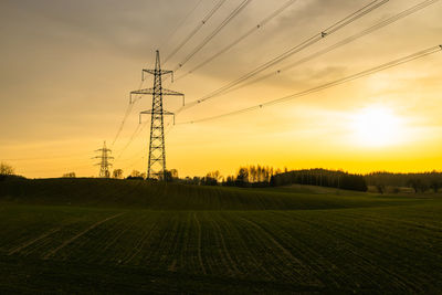 High voltage electricity pole and transmission power lines at sunset