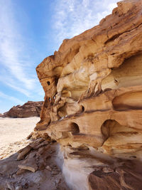 Rock formations on beach against sky