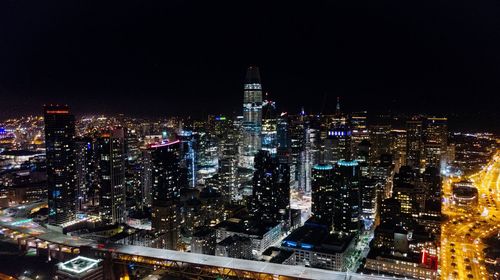 Illuminated cityscape against sky at night