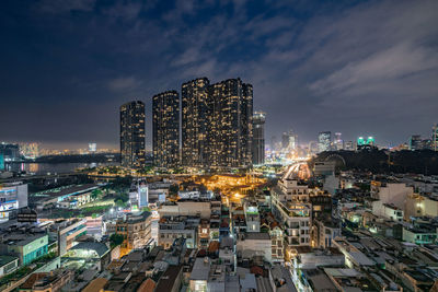 High angle view of illuminated buildings against sky at night