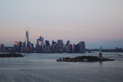 Sea with city in background at dusk