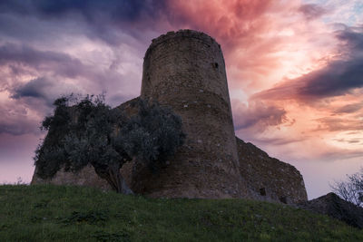 Rock formations on field against sky during sunset