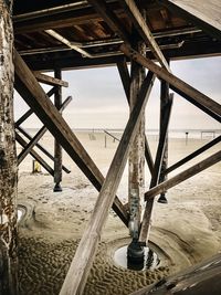 Low angle view of pier over sea against sky