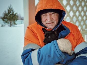 Portrait of man with dog on snow