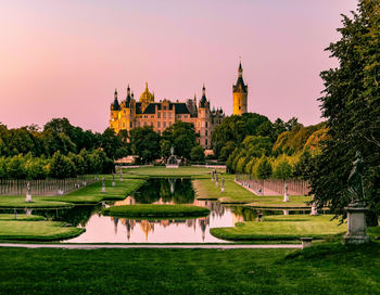 View of castle by lake against sky