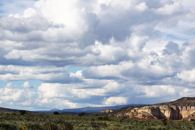 Countryside landscape against cloudy sky