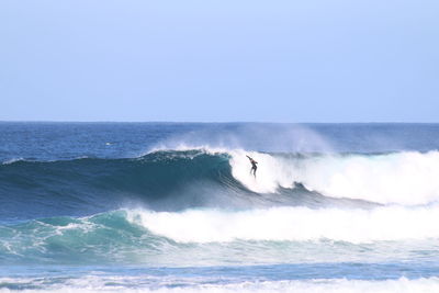 Man surfing in sea against clear sky