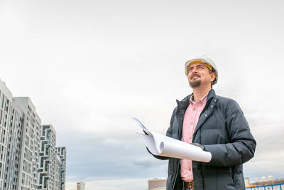 Young man standing against sky