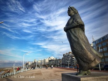 Statue of city against cloudy sky