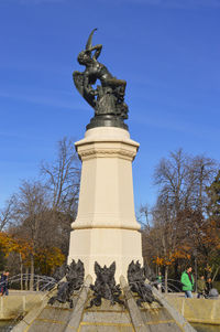 Low angle view of statue against blue sky