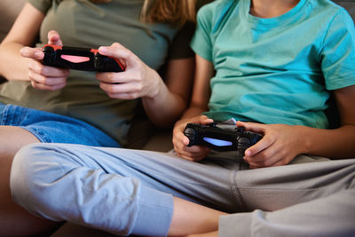 Boy and woman playing video game at home