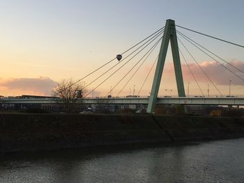 Bridge over river against sky during sunset