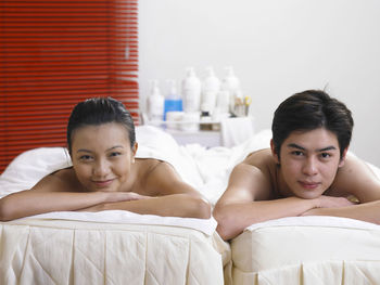 Portrait of young couple lying on massage tables