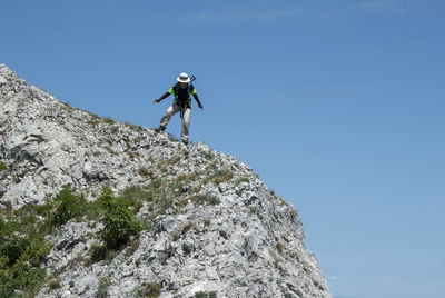 Low angle view of man climbing on mountain