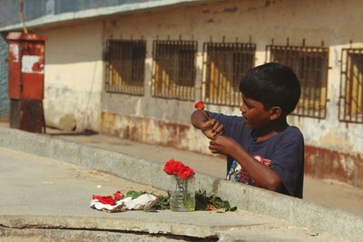 Boy making bouquet on street