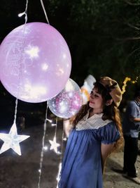 Full length of a smiling young woman holding balloons