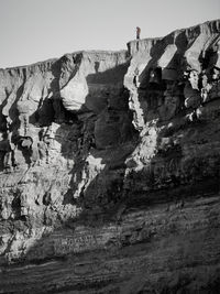 Low angle view of man standing by cliff