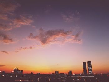 Illuminated buildings against sky during sunset