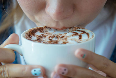 Close-up of young woman drinking coffee