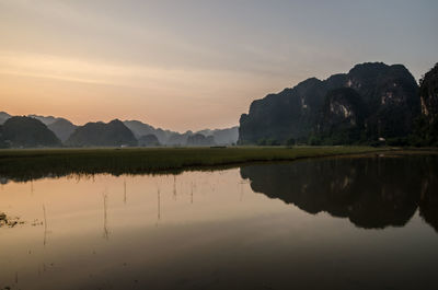 Scenic view of lake by mountains against sky