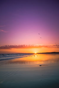 Scenic view of sea against romantic sky at sunset