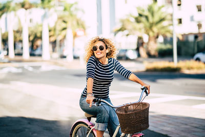 Smiling woman riding bicycle on road