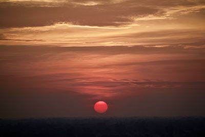 Silhouette landscape against dramatic sky during sunset