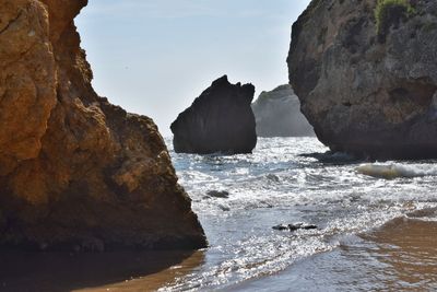 Rocks on beach against sky