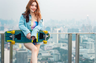 Portrait of woman standing against railing
