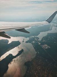 Cropped image of airplane wing over sea