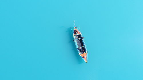 High angle view of kite flying over blue background