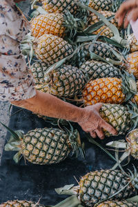 High angle view of senior woman buying pineapple at market stall