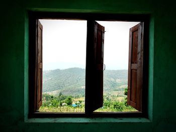 Trees seen through window of house