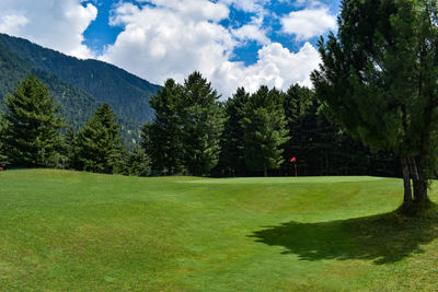 Scenic view of golf course against sky