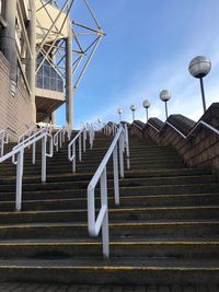 Low angle view of steps amidst buildings against sky