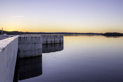 Scenic view of lake against clear sky during sunset