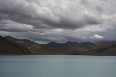 Scenic view of lake by mountains against sky